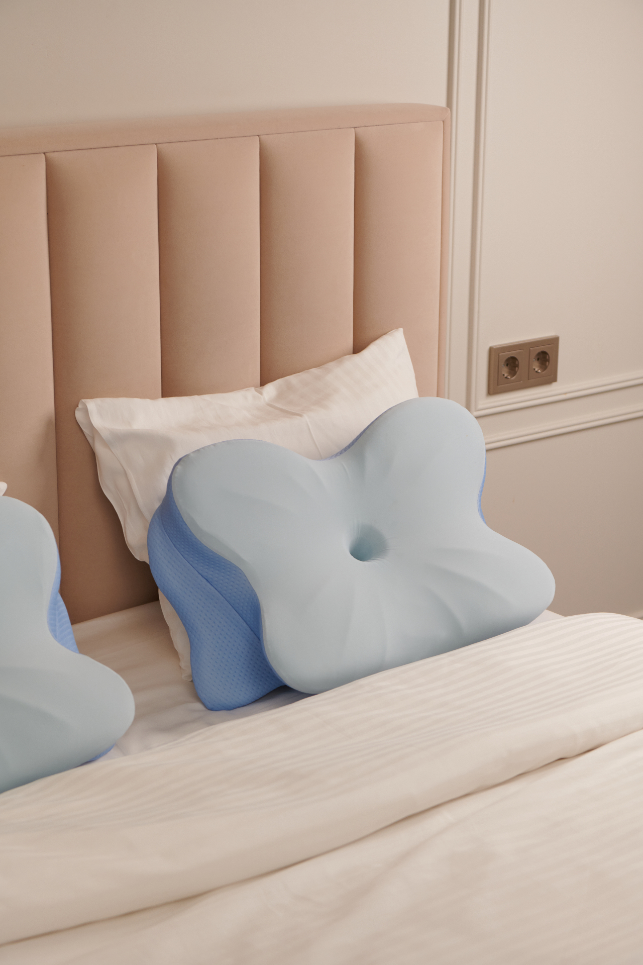 Contoured memory foam pillow with cooling cover on a bed